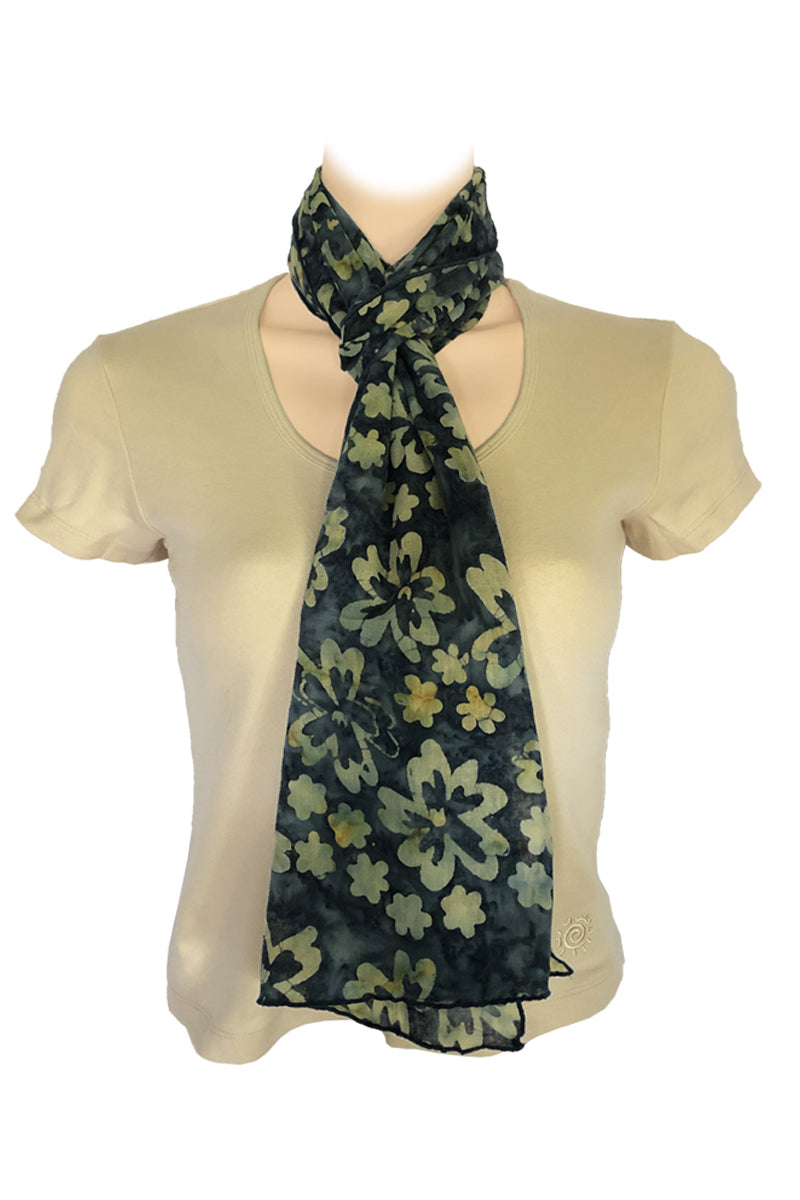 A lightweight scarf with a dark green and olive floral pattern, styled around the neck