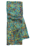 A folded patterned scarf or sari with a dense floral print in blue, yellow, and orange tones.