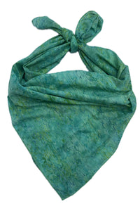 A green and teal batik-patterned scarf tied in a knot.