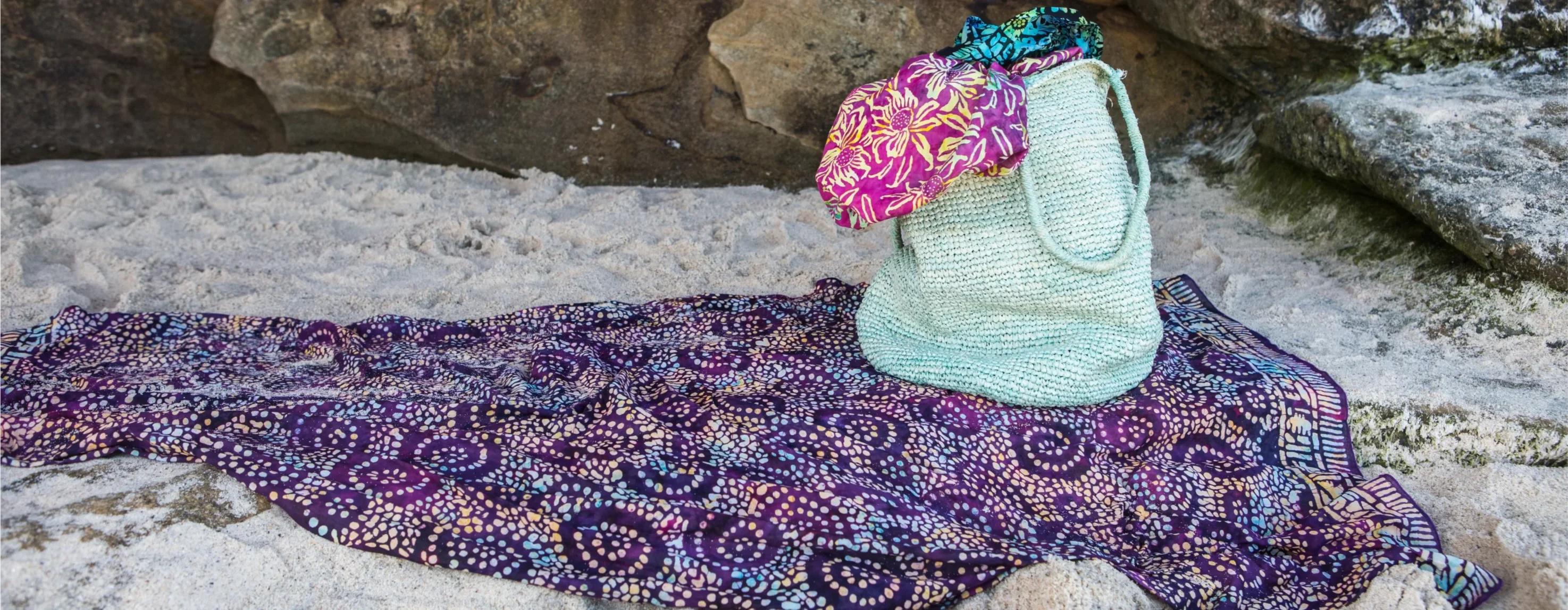 Colorful patterned scarf and bag on a rock with a natural background