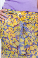 Floral patterned pants with a yellow belt and purple top.
