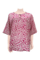 A pink and white batik silk kaftan top displayed on a mannequin.