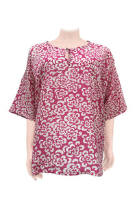 A pink and white batik silk kaftan top displayed on a mannequin.